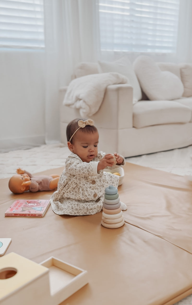 toddler playing with toy on play mat