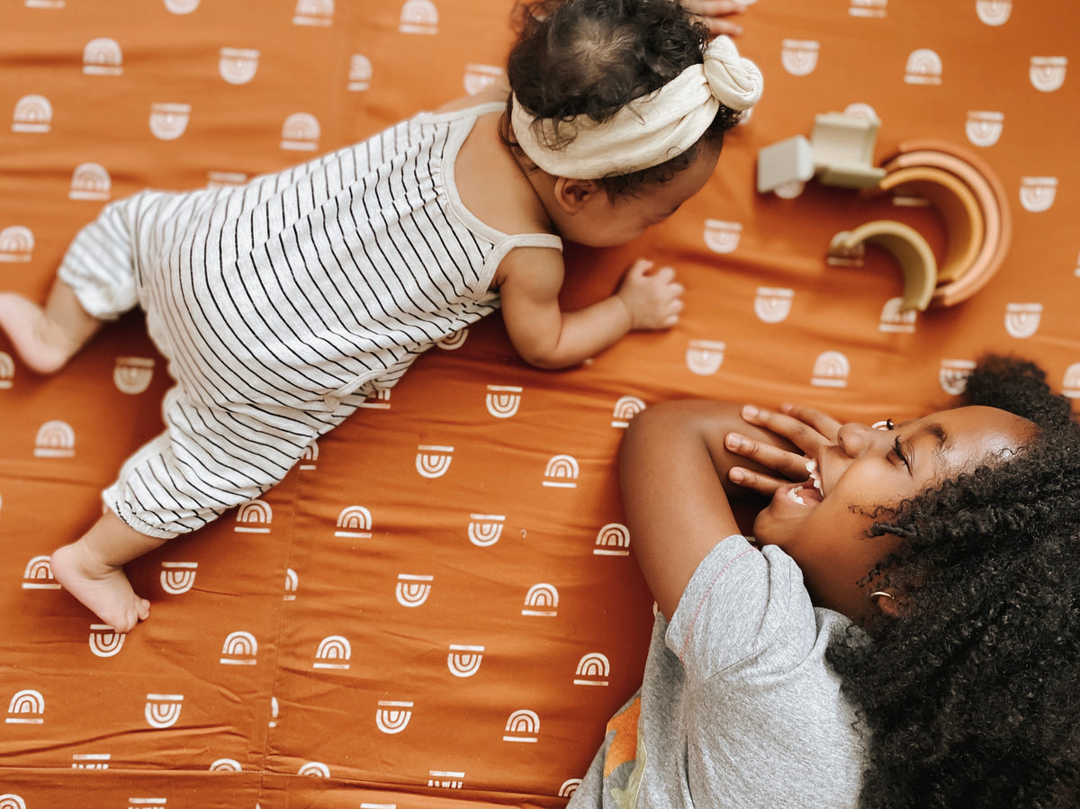 baby and toddler playing on a toki mats play mat