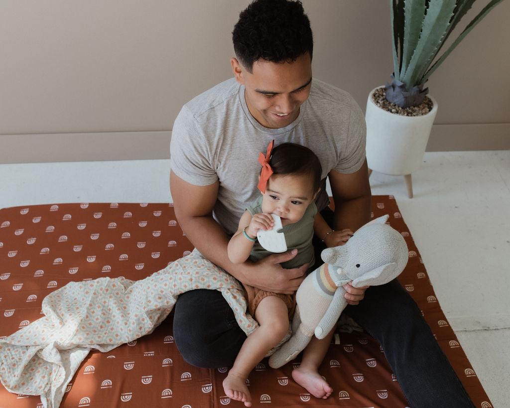 dad and baby sitting on a toki mats play mat
