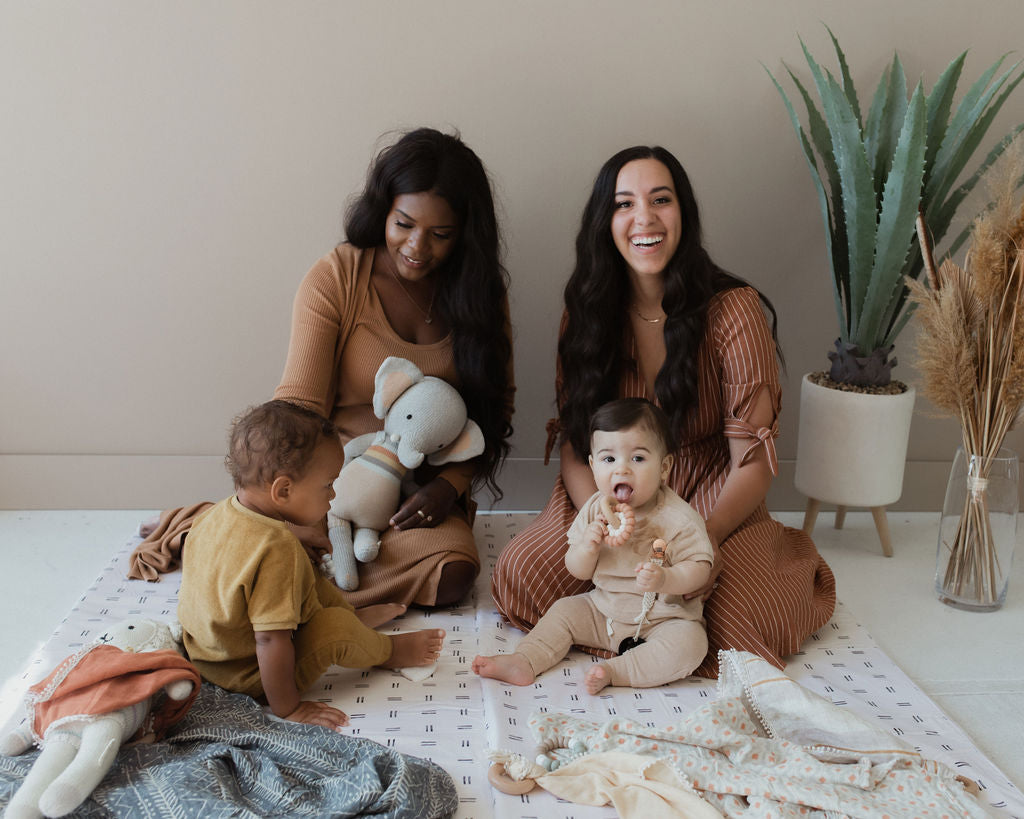 two moms with their babies on a toki mats play mat