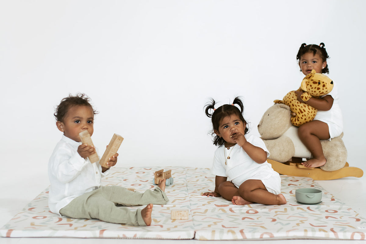 children of color playing on diversity collection play mat pastel party