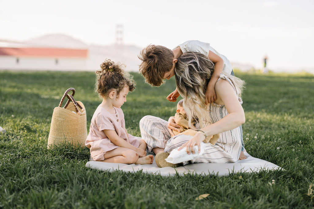 toki mats CEO and founder eli yonas playing with her kids on a toki mat on the grass