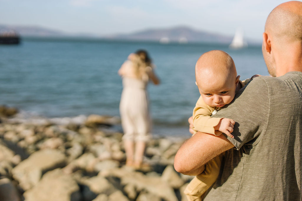 baby in dad's arms at the beach