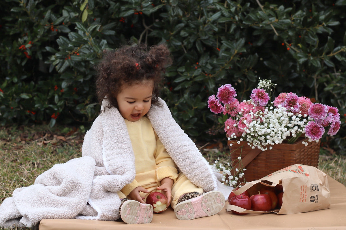toddler sitting on a vegan leather toki mat outside