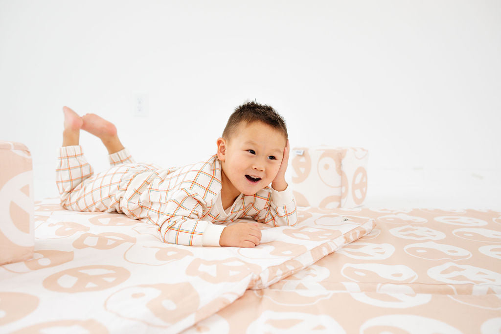 child laying on a toki mats play mat with lena corwin's ying and yang print design