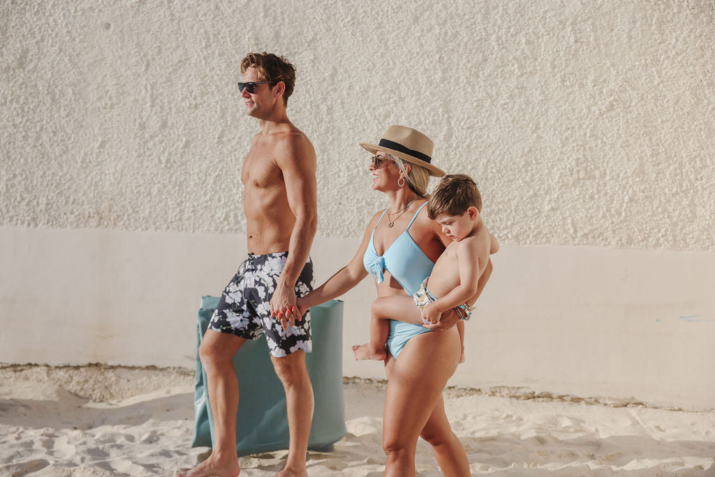 family walking with a toki mats play mat on the beach