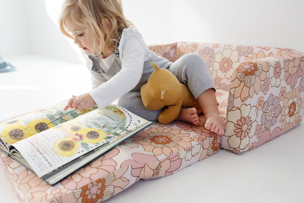 toddler laying on a toki mats play couch