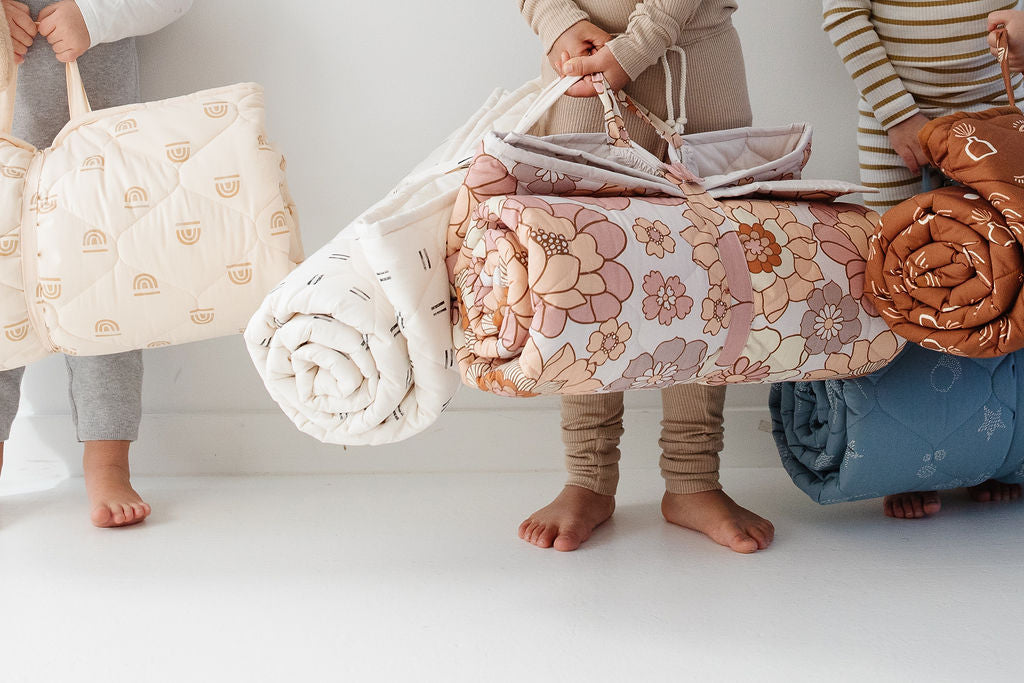 kids holding toki mats picnic blankets