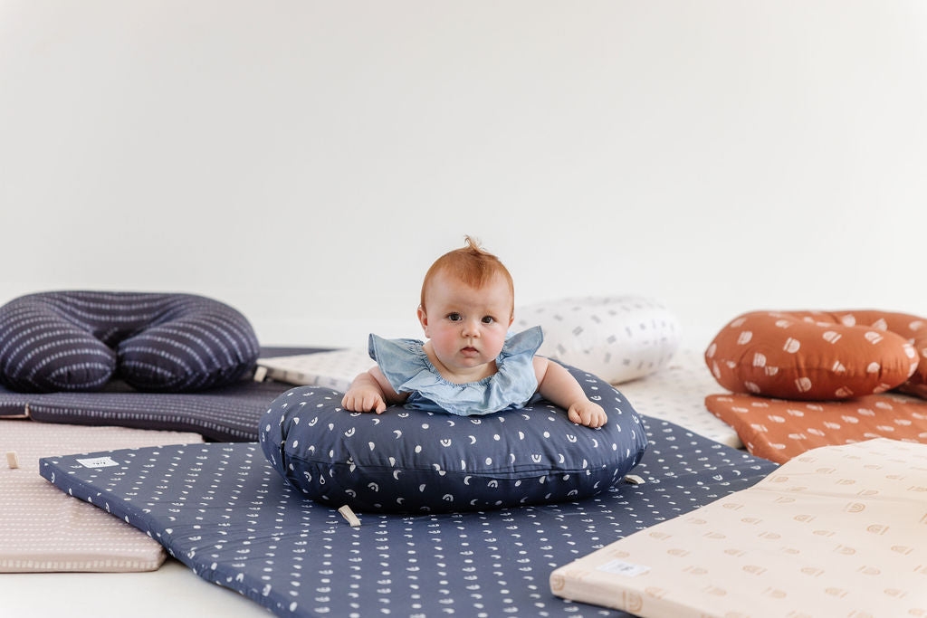 baby doing tummy time on toki mats nursing pillow