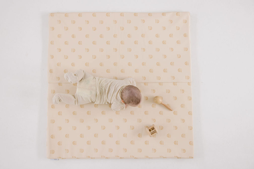 baby doing tummy time on a toki mats play mat