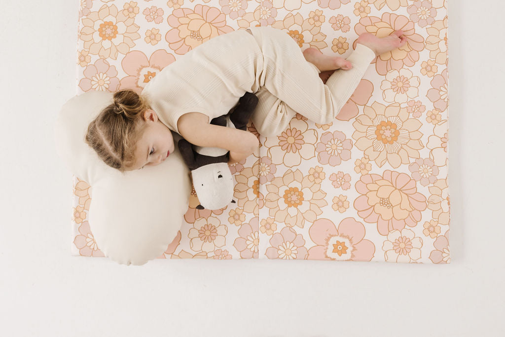 little girl laying on her toki mats play mat