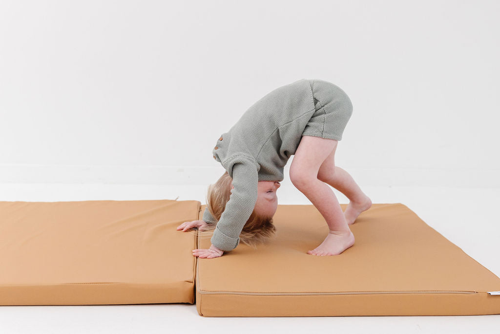 child doing a somersault on a toki mats play cushion