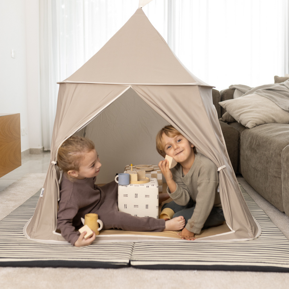 Two children inside a play tent playing with blocks